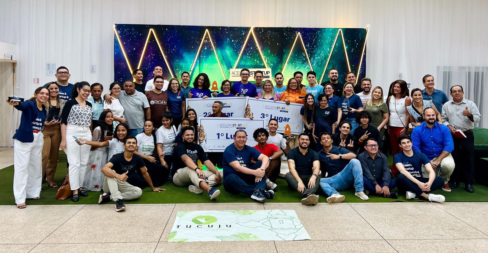 Grupo de participantes reunido no palco do Acelera Startup Amapá com placas de premiação, em 2023.